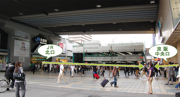JR北口、もしくは京阪中央口を出て矢印方向へお進み下さい。<br>
R北口、もしくは京阪中央口を出て矢印方向へお進み下さい。”></li>
<li>立体駐輪所の脇を抜けてください。<br>
<img src=